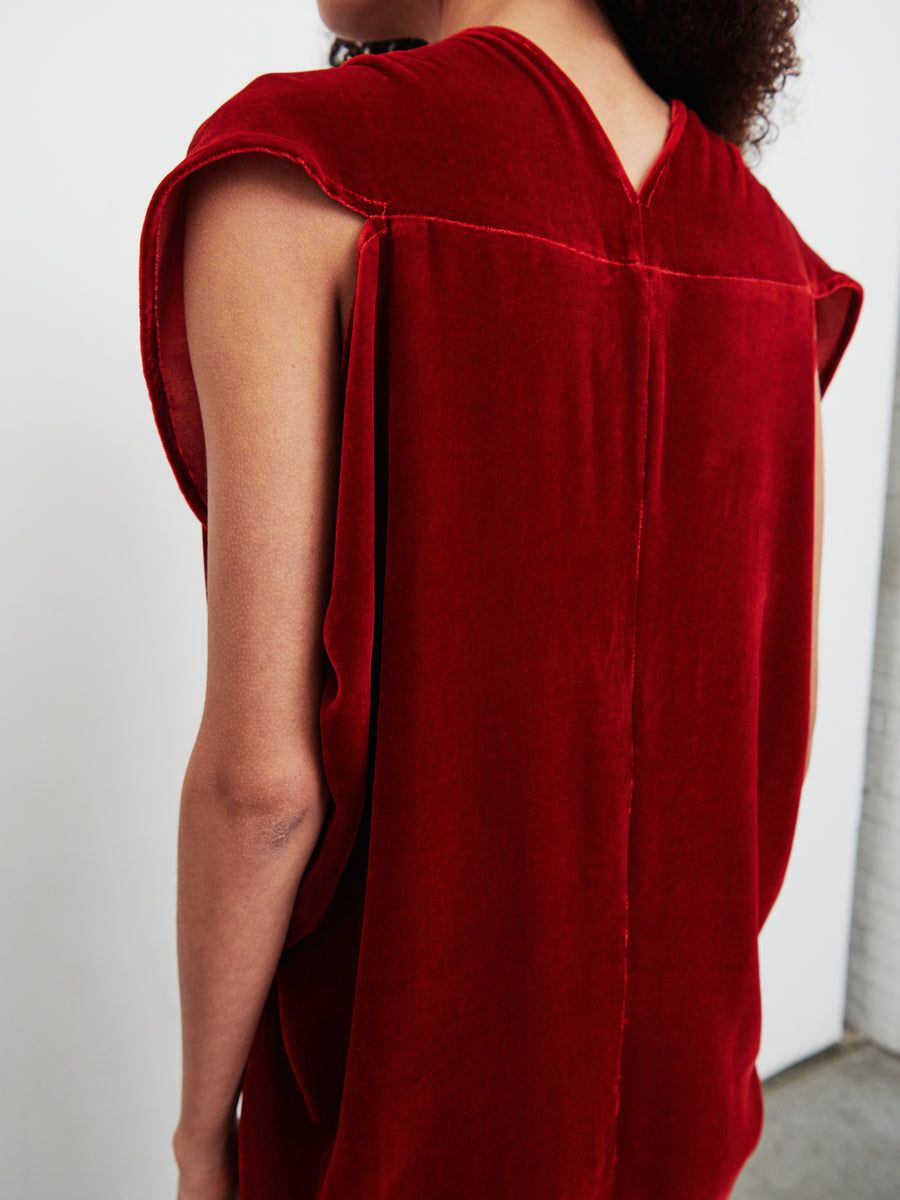 A person wearing the sleeveless Long Issa Dress in red velvet by Zero + Maria Cornejo is turned slightly away from the camera, highlighting the back and shoulder seam details.