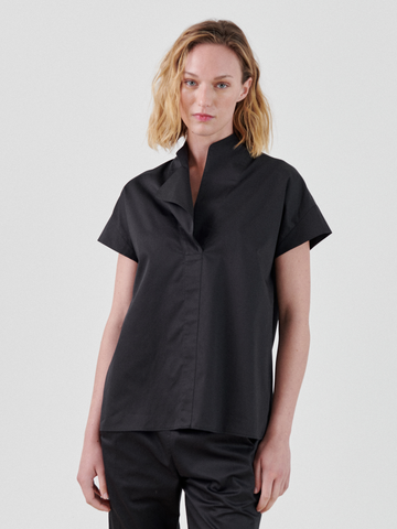 A woman in a short-sleeved Adi Top made of black cotton shirting by Zero + Maria Cornejo.