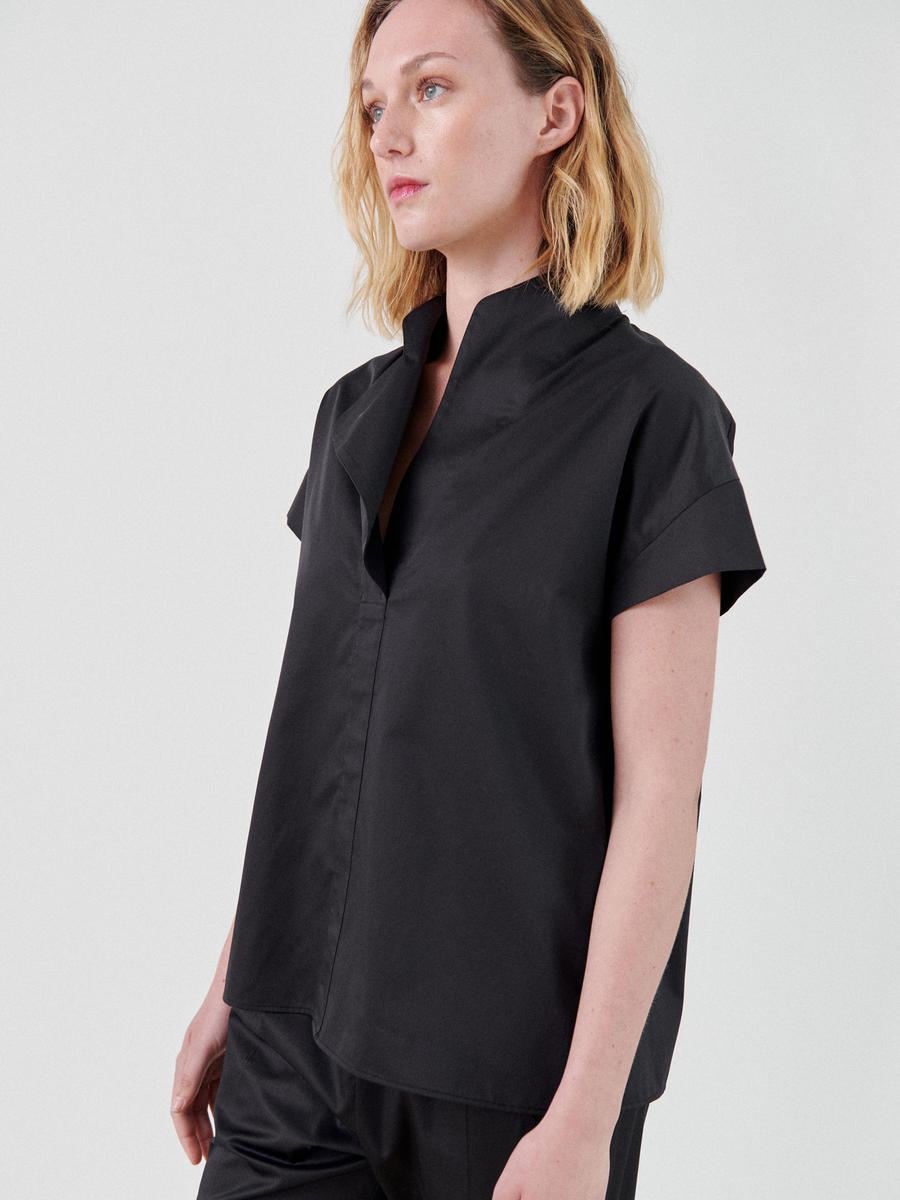 A woman in a black, short-sleeved Adi Top by Zero + Maria Cornejo.