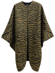 The Koya Coat by Zero + Maria Cornejo is a loose-fitting, tiger-striped poncho in brown and black featuring wide sleeves, two front pockets, and a striking cocoon silhouette, displayed on a plain white background.