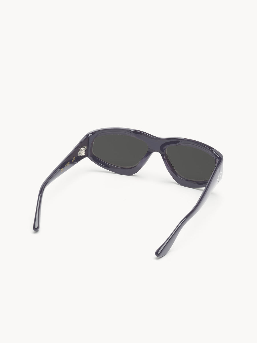The Port Tanger Irfan by Port Tanger are unisex black sunglasses with dark lenses, shown upside down on a white background. Their slightly open arms provide classic style and reliable UVA/UVB protection.