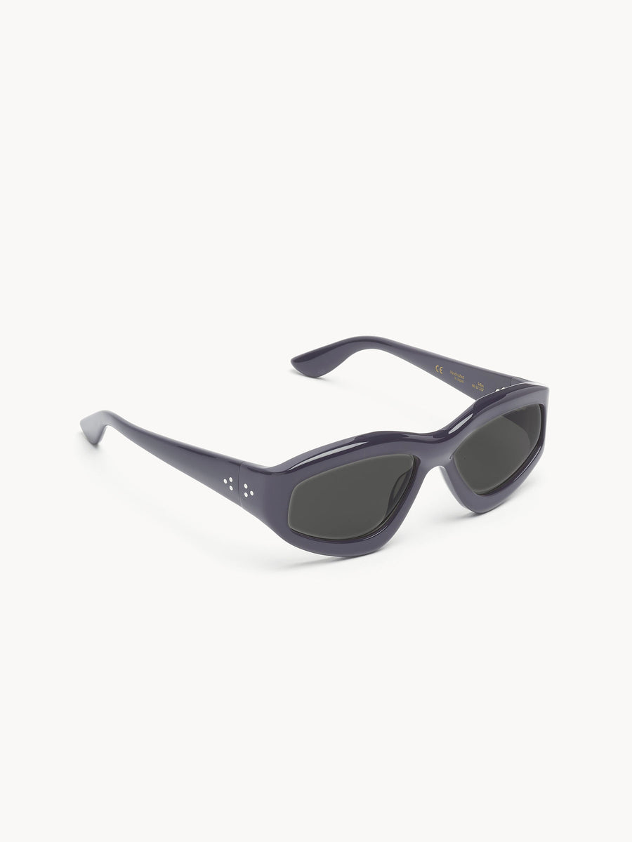 The Port Tanger Irfan sunglasses by Port Tanger feature rectangular dark gray unisex frames with thick edges and black lenses, providing reliable UVA/UVB protection. Shown on a white background.