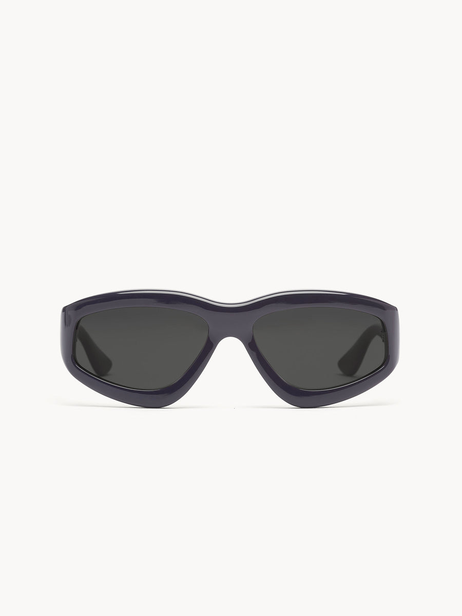 The Port Tanger Irfan by Port Tanger is a pair of black wraparound sunglasses with dark tinted lenses, shown on a plain white background, delivering unisex style and reliable UVA/UVB protection.