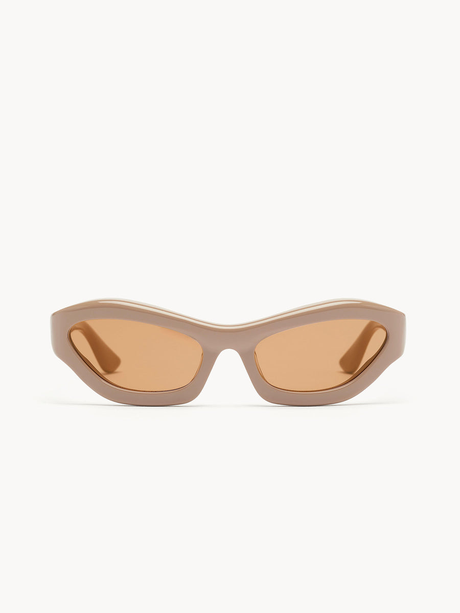 The Port Tanger Hayya by Port Tanger are beige, oval cat-eye sunglasses with thick frames and brown-tinted lenses that provide UVA/UVB protection, shown on a white background.