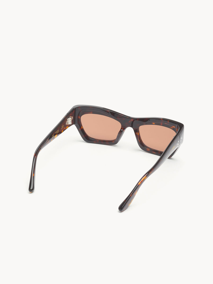 The Port Tanger Ayreen by Port Tanger is shown from the back, highlighting its tortoiseshell cat-eye frames and brown-tinted lenses with 100% UVA/UVB protection, set against a plain white background.