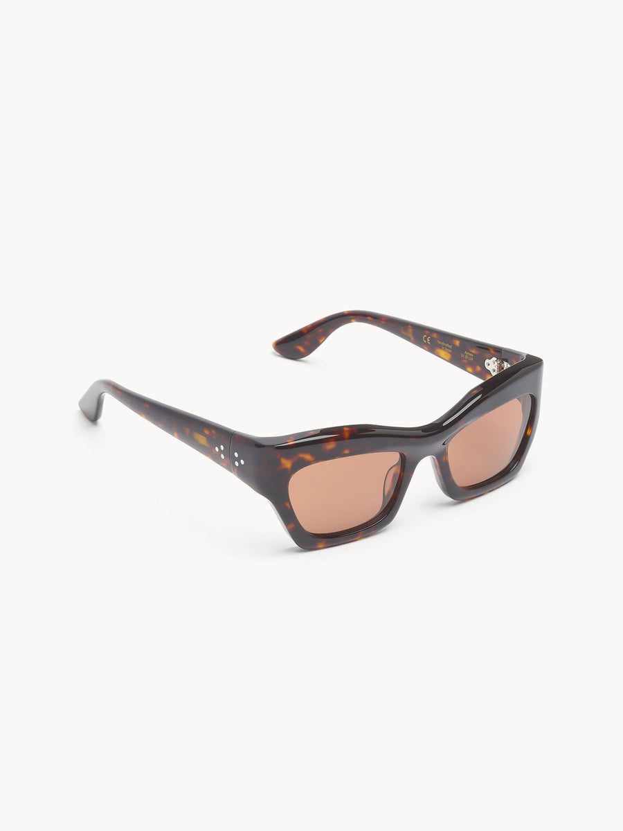 Port Tanger Ayreen by Port Tanger features rectangular sunglasses with thick, dark tortoiseshell frames and light brown tinted lenses, handcrafted in Japan for 100% UVA/UVB protection, shown on a white background.