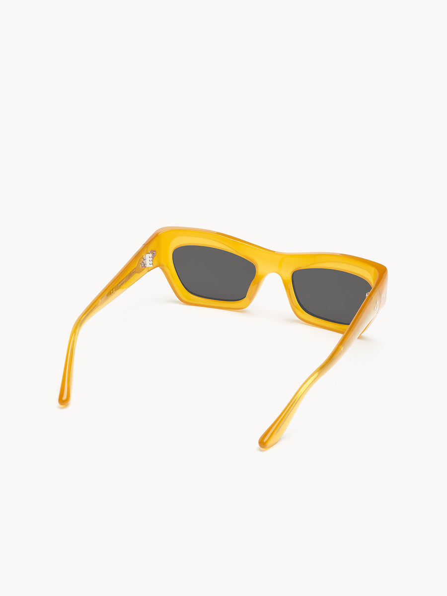 Port Tanger Ayreen sunglasses by Port Tanger, shown from the back on a white background; handcrafted in Japan with yellow frames and dark rectangular lenses, arms slightly angled outward.