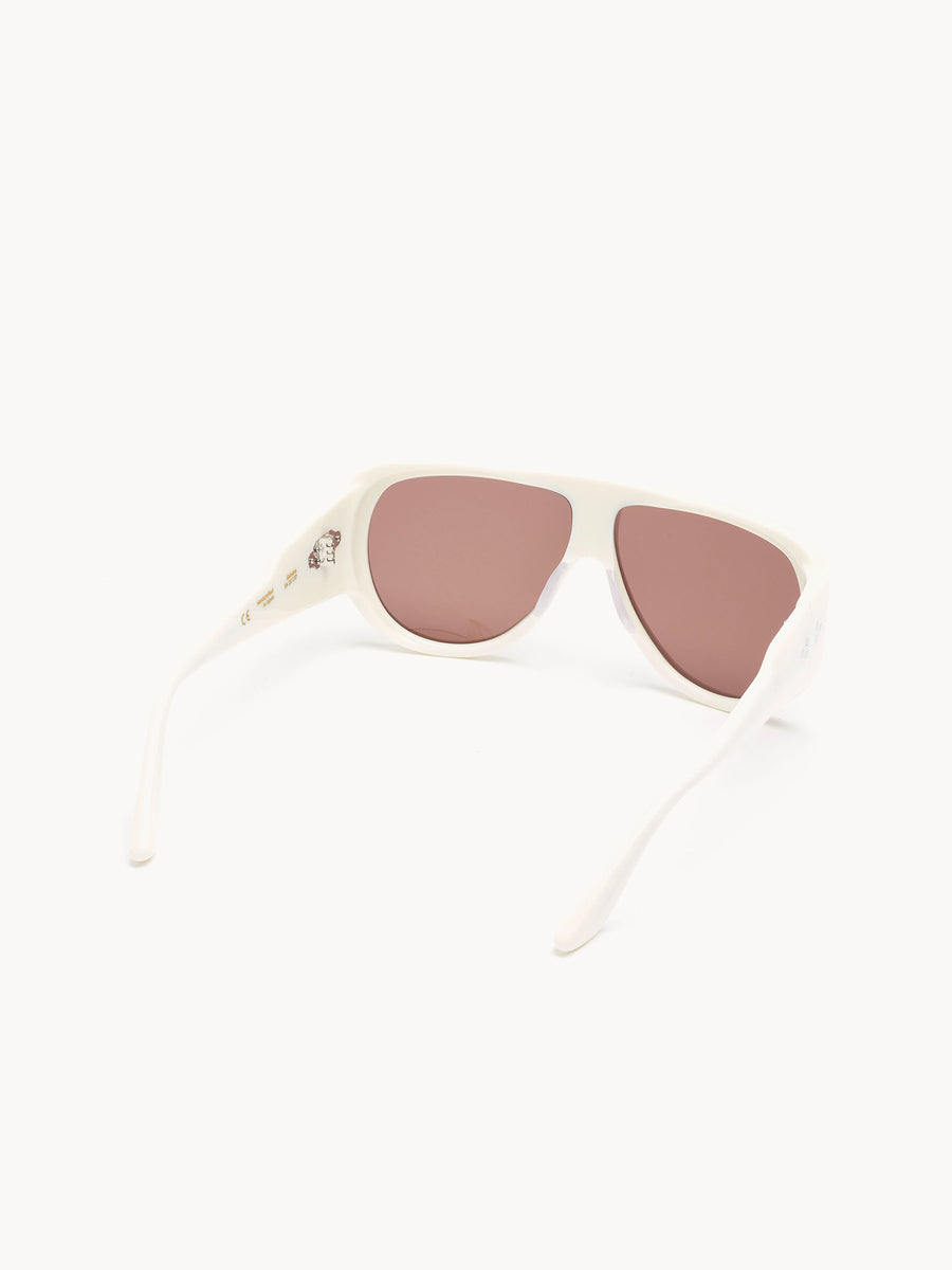 The Port Tanger Gambia sunglasses by Port Tanger feature white frames, slightly curved arms, and brown-tinted lenses. Handcrafted in Japan, they are shown on a white background facing away from the viewer.