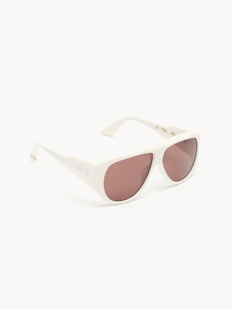 Port Tanger Gambia sunglasses by Port Tanger feature a white aviator frame and lightly tinted pink lenses, handcrafted in Japan and shown on a plain white background.