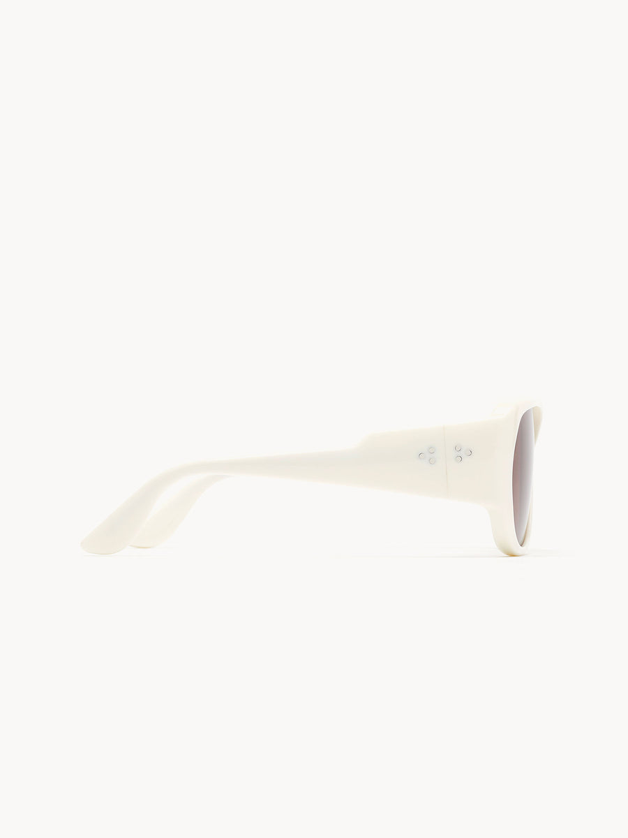 Side view of Port Tanger Gambia white sunglasses by Port Tanger, featuring round frames and thick, smooth temples, handcrafted in Japan and displayed against a plain white background.