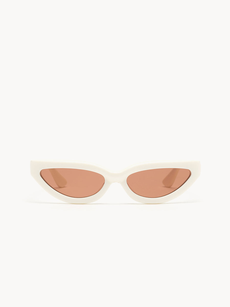 The Port Tanger Fanna by Port Tanger features white oval frames and light brown tinted lenses, handcrafted in Japan with 100% UVA/UVB protection, displayed against a plain white background.