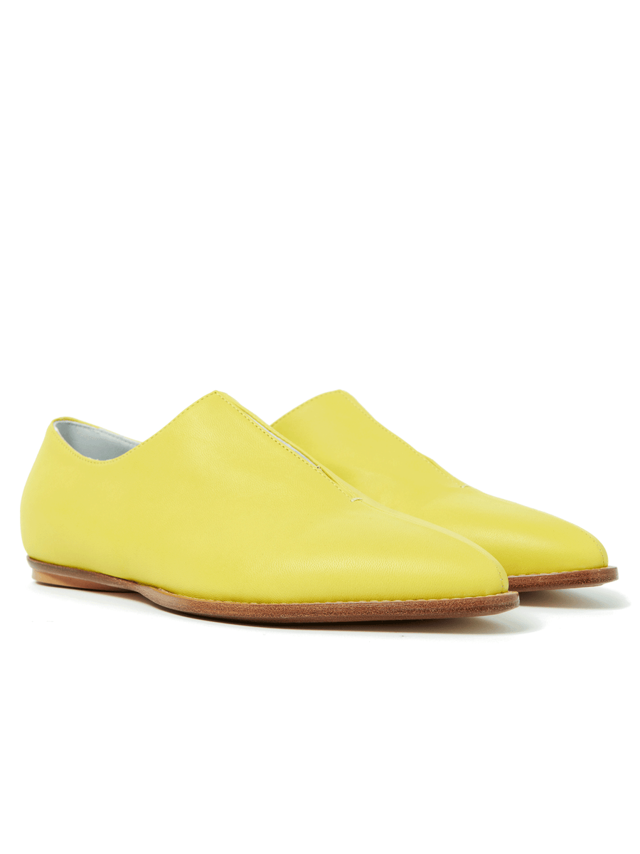 The Kiara Oxford by Zero + Maria Cornejo is a sleek, yellow leather flat crafted from luxurious Nappa leather. Featuring a smooth surface, minimalist design, wooden heel, and rounded toe on a white background, they're available in Italian sizing for the perfect fit. Final Sale.