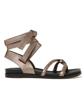 The Limi Sandal by Zero + Maria Cornejo is a brown open-toe sandal with a flat sole and strappy design, featuring a high wrap ankle tie with a decorative bow. Crafted in metallic leather, this elegant and modern style embraces Italian sizing for the perfect fit. Final Sale.