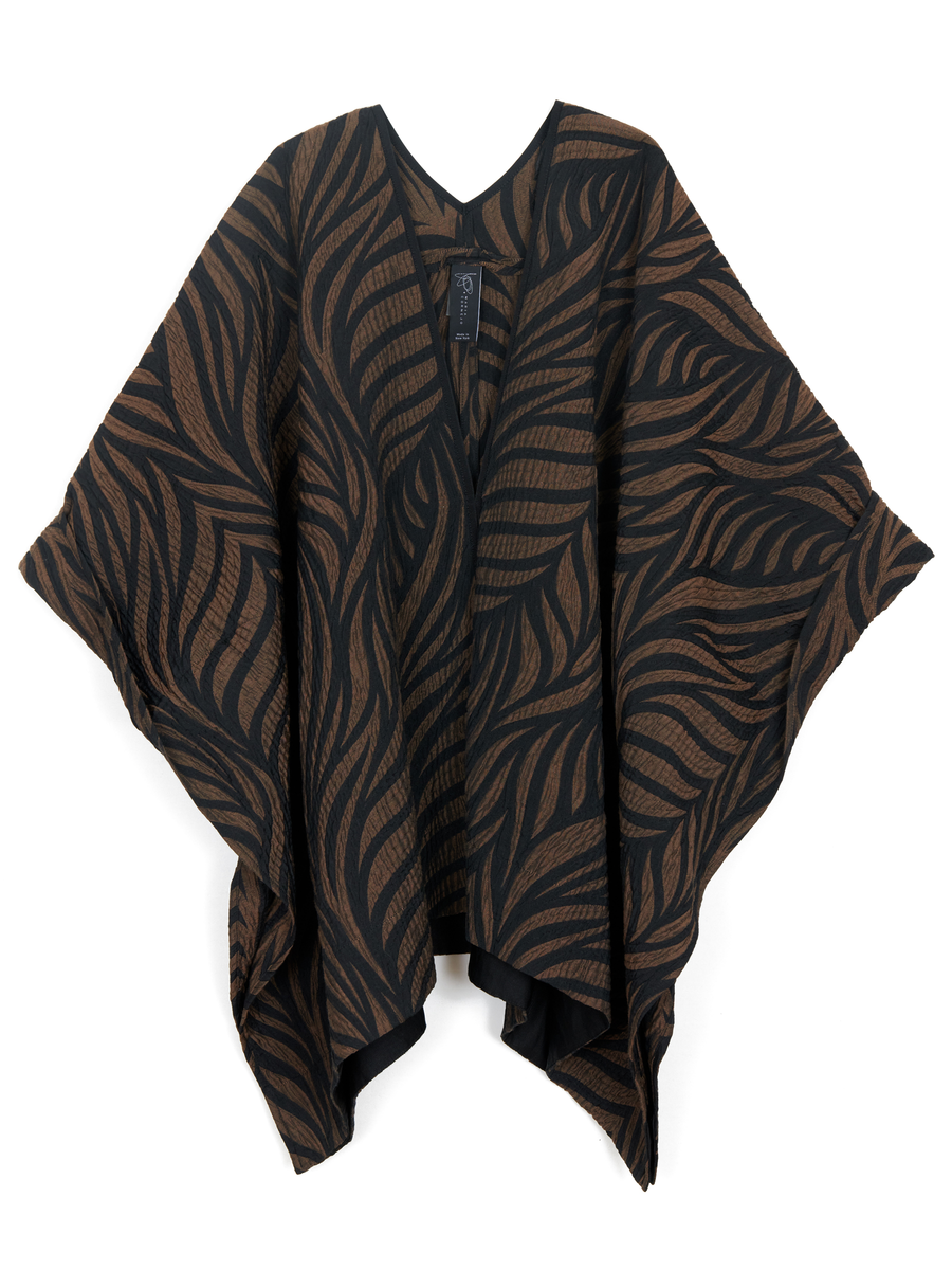 A poncho-style garment made of recycled polyester with a brown and black leaf pattern. The **Eve Square Shrug** by **Zero + Maria Cornejo** has a V-neck and draped, flowing sleeves. The design features an open front and loose, relaxed fit, blending sustainability with comfort effortlessly.