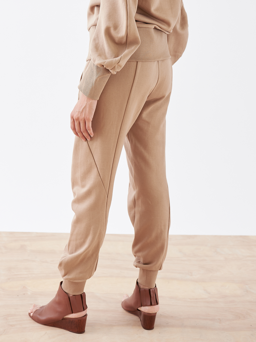 A person wearing Akeo Sweatpant by Zero + Maria Cornejo with an elastic banded waist and matching brown shoes.