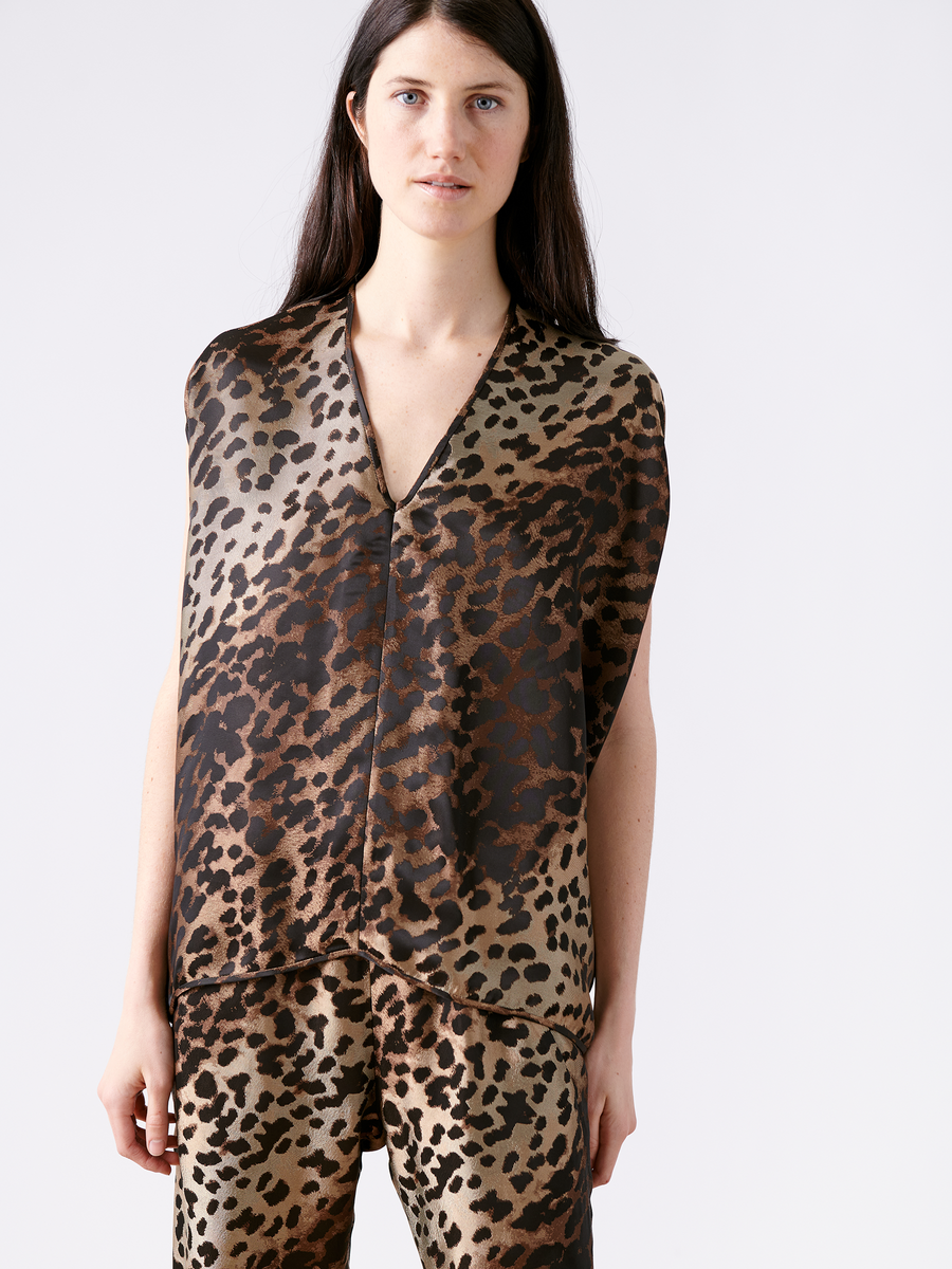 A person with long dark hair is wearing the Ina Tank - Final Sale by Zero + Maria Cornejo, featuring a sleeveless brown and black leopard print pattern crafted from FSC certified viscose. They stand against a plain white background, looking directly at the camera.